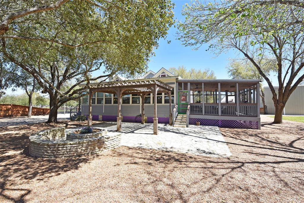 This view is looking at the rear of the Main house. Notice the firepit, pergola, screen room to the right and sunroom to the left. The gravel keeps the property very tidy.