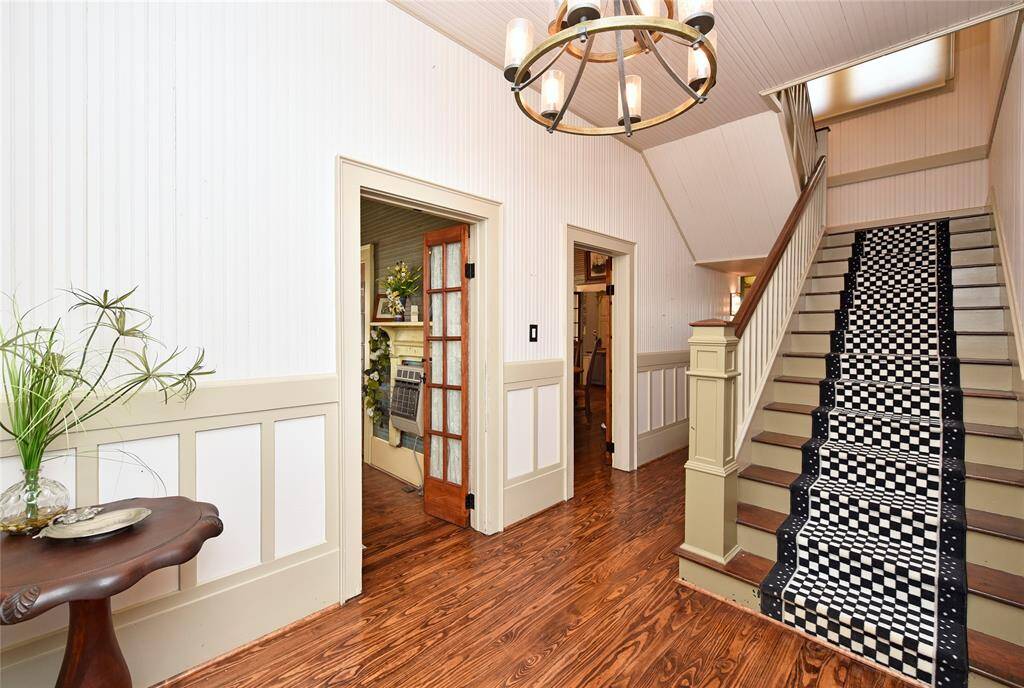 The foyer in the Main home welcomes guests with period specific lighting, bead-board walls, original wood flooring and pure charm.