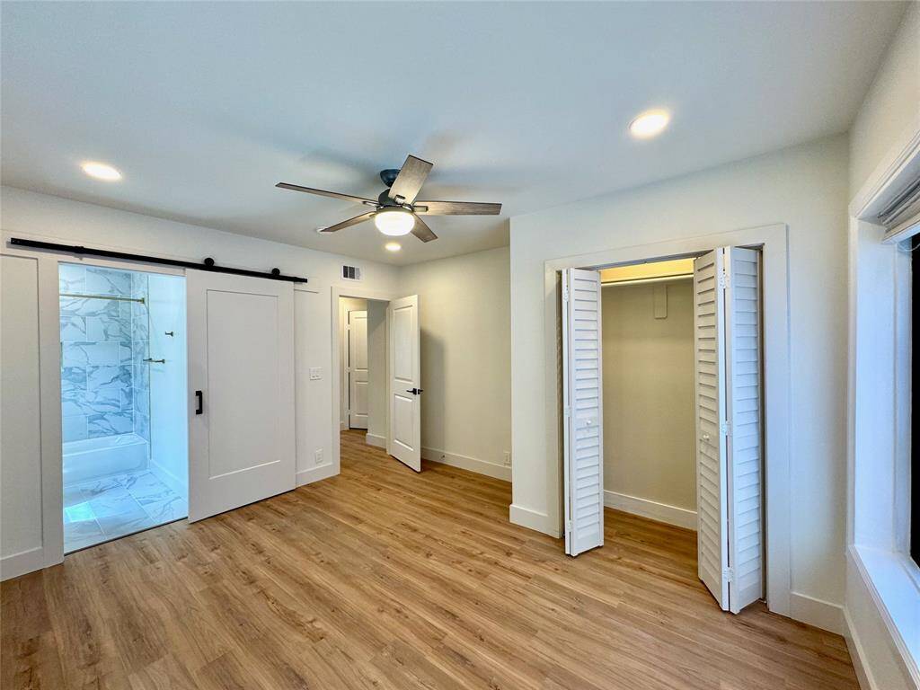 Primary bedroom is located in the back of the house for more privacy. The barn door is for the bathroom.
