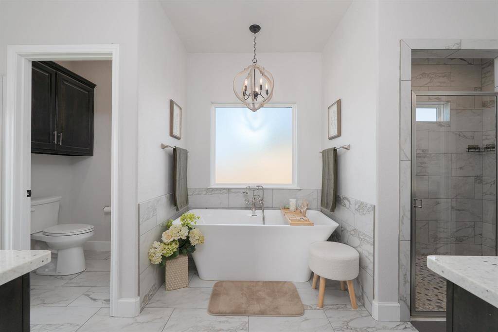 Step into the luxurious primary en suite to unwind and relax. This luxe bathroom offers an ample soaking tub and oversized shower.