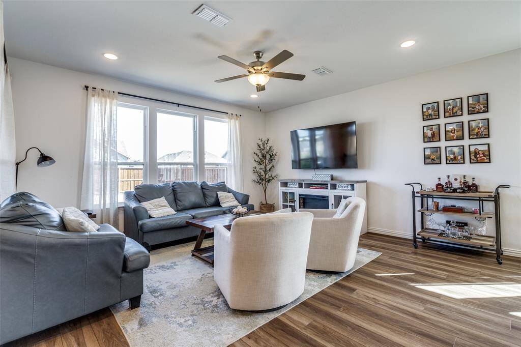 Living room with ceiling fan, visible vents, wood finished floors, and recessed lighting