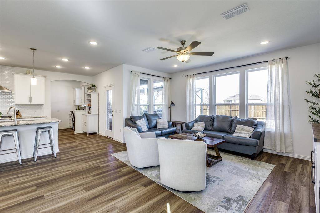 Living room featuring a ceiling fan, visible vents, dark wood finished floors, recessed lighting, and arched walkways