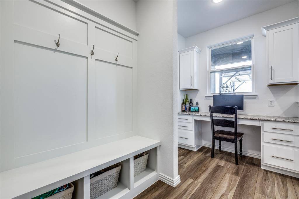 Mudroom featuring dark wood finished floors and built in desk