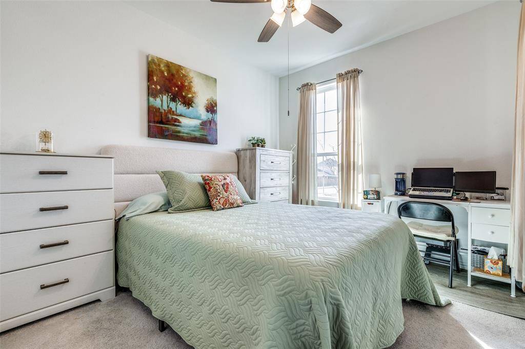 Bedroom with light colored carpet and a ceiling fan