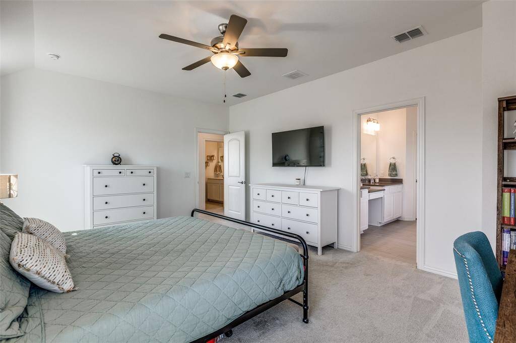 Bedroom featuring light carpet, visible vents, and lofted ceiling