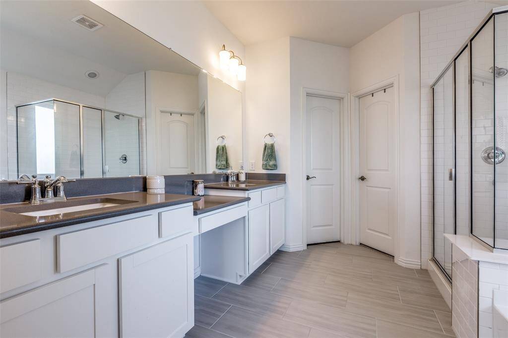 Full bathroom with visible vents, a stall shower, and vanity