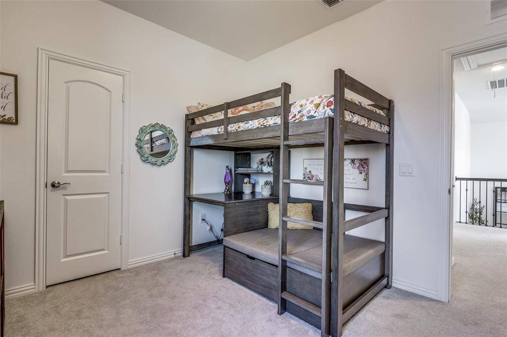 Unfurnished bedroom with carpet flooring, visible vents, attic access, and baseboards