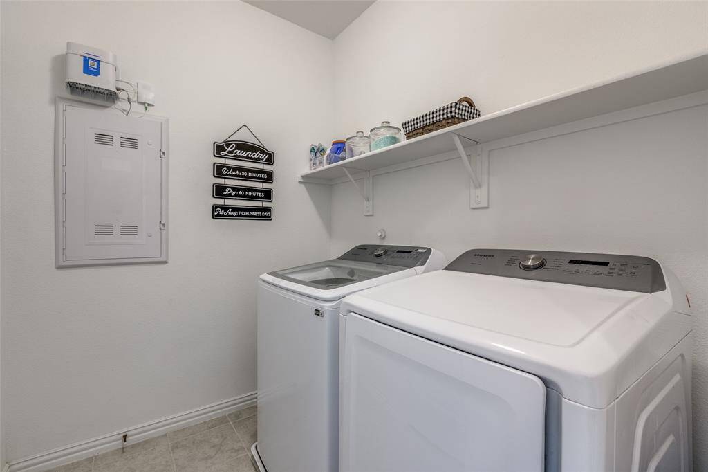 Laundry room with baseboards, separate washer and dryer, light tile patterned flooring, and laundry area