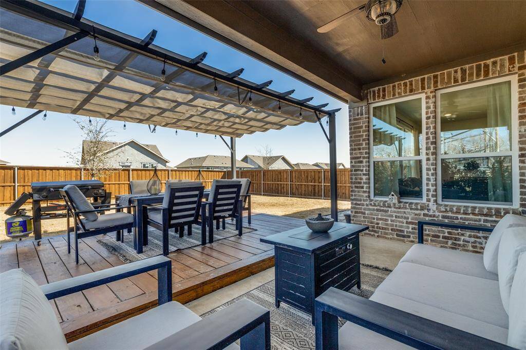 Wooden terrace featuring a fenced backyard, an outdoor hangout area, outdoor dining space, and a pergola