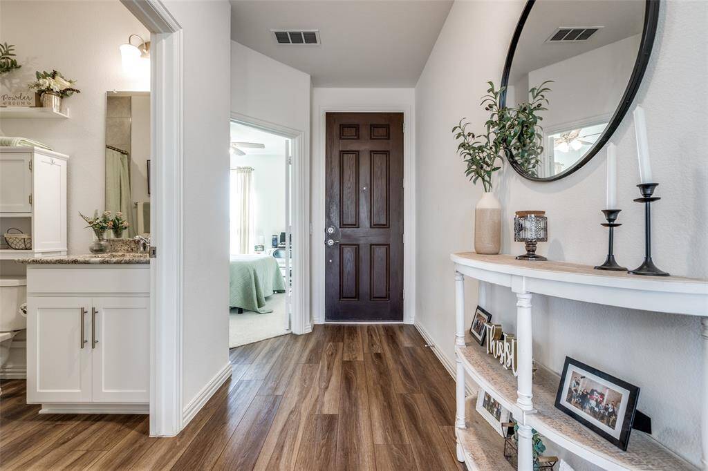 Foyer entrance featuring visible vents, baseboards, and dark wood finished floors