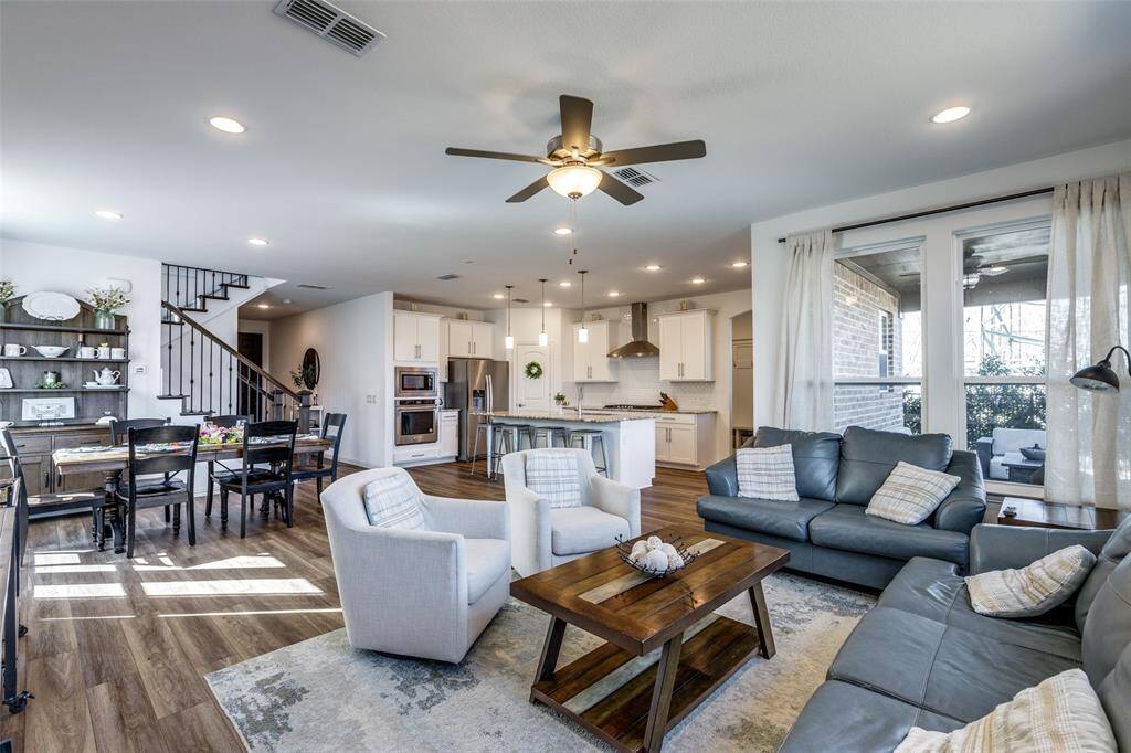 Living room with stairway, dark wood-style floors, visible vents, recessed lighting, and ceiling fan