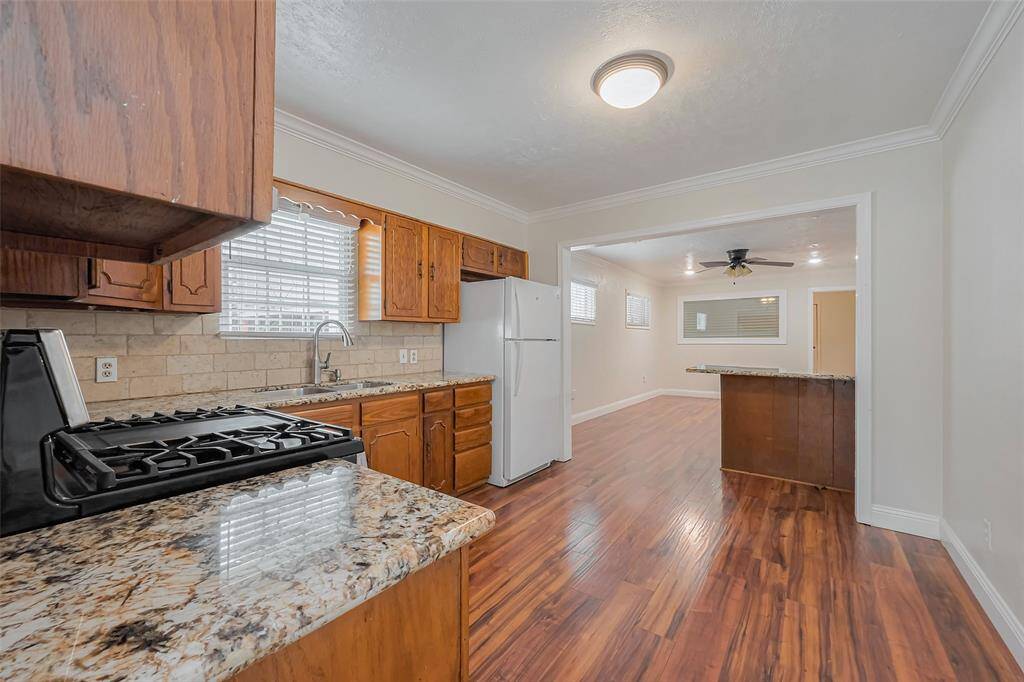 A wide, open wall cutout connects the kitchen and dining area, maintaining an airy feel while defining each space. A convenient breakfast bar sits beneath the opening, offering a casual dining spot or serving area.