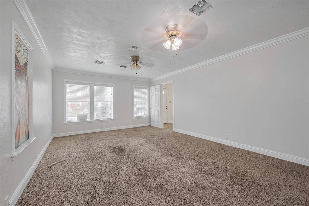 Natural light streams through large windows, enhancing the sense of space. The crisp white walls and ceiling further amplify the room’s open and airy ambiance.