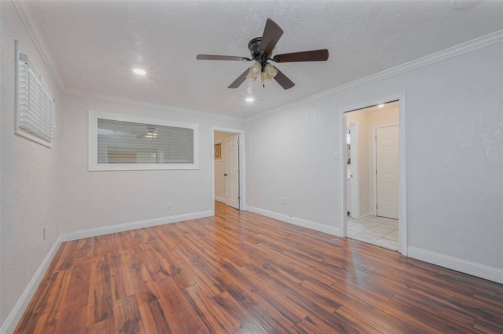Rich wood-like flooring adds warmth to this dining area, beautifully illuminated by recessed lighting. Its open layout makes it a versatile space for meals and gatherings.