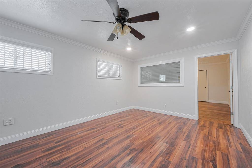 A ceiling fan provides comfort, while windows bring in natural light, making this dining space both inviting and practical. The neutral tones offer a clean slate for any décor style.