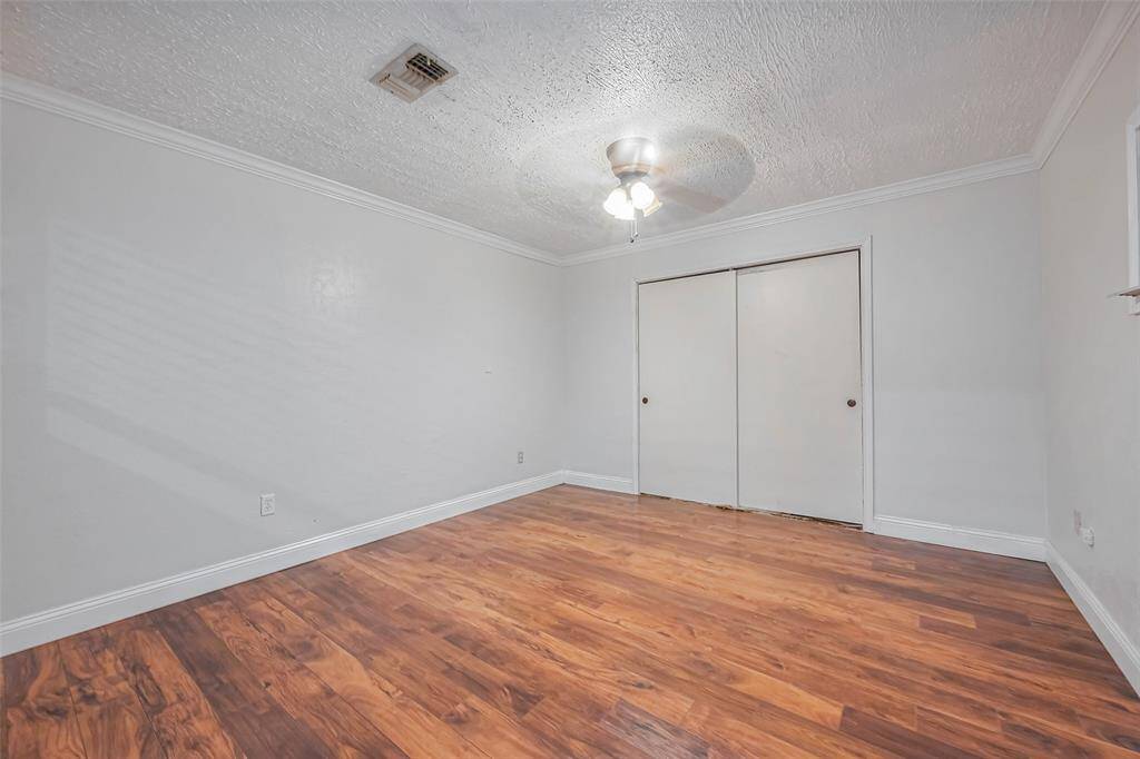 This additional room, located beside the dining space, offers flexibility for use as a bedroom or home office. Its neutral finishes and spacious layout make it adaptable.