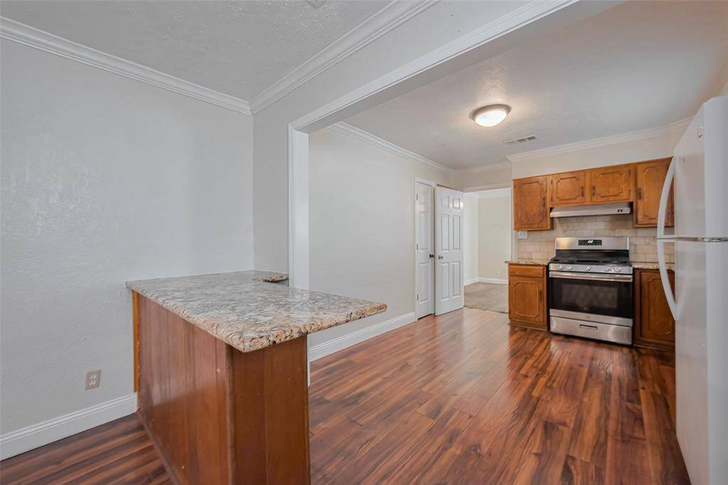 The breakfast bar serves as a casual dining spot while subtly defining the kitchen from the dining area.
