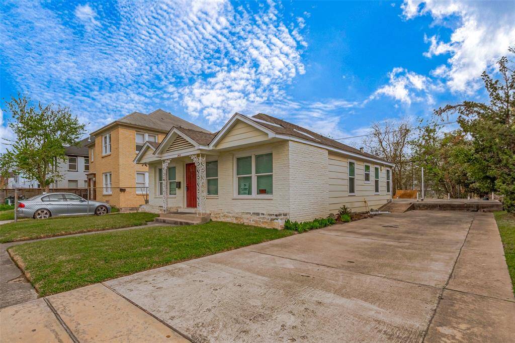 A long, neatly paved driveway runs alongside the home, providing ample parking space.