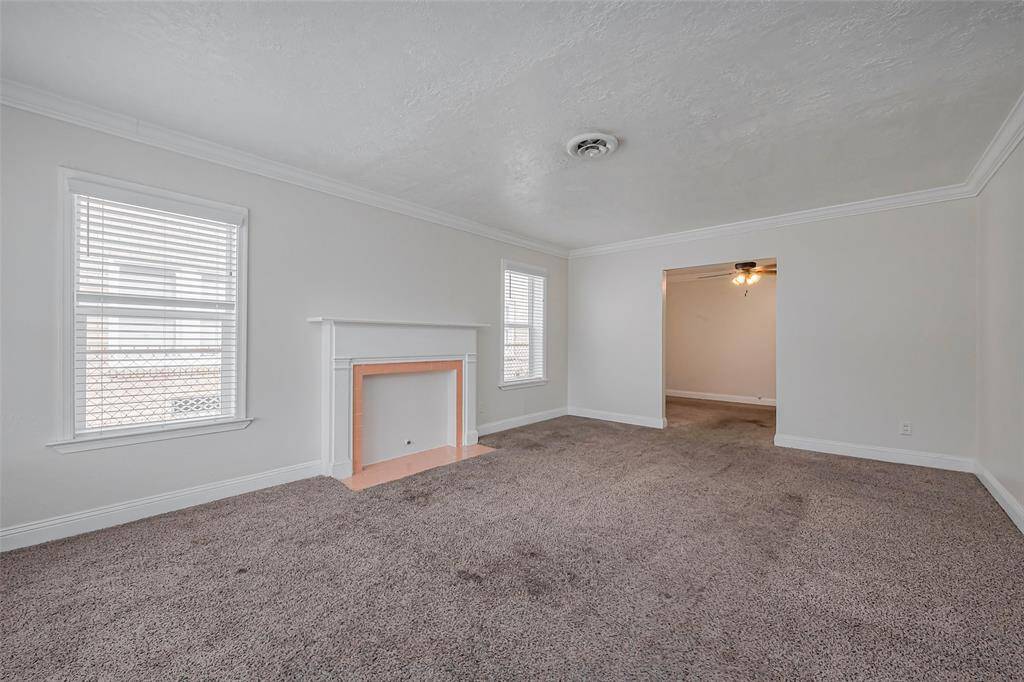 The focal point of this comfortable living space is a decorative fireplace, adding a touch of character. Large windows invite ample natural light, creating an airy and relaxed atmosphere.