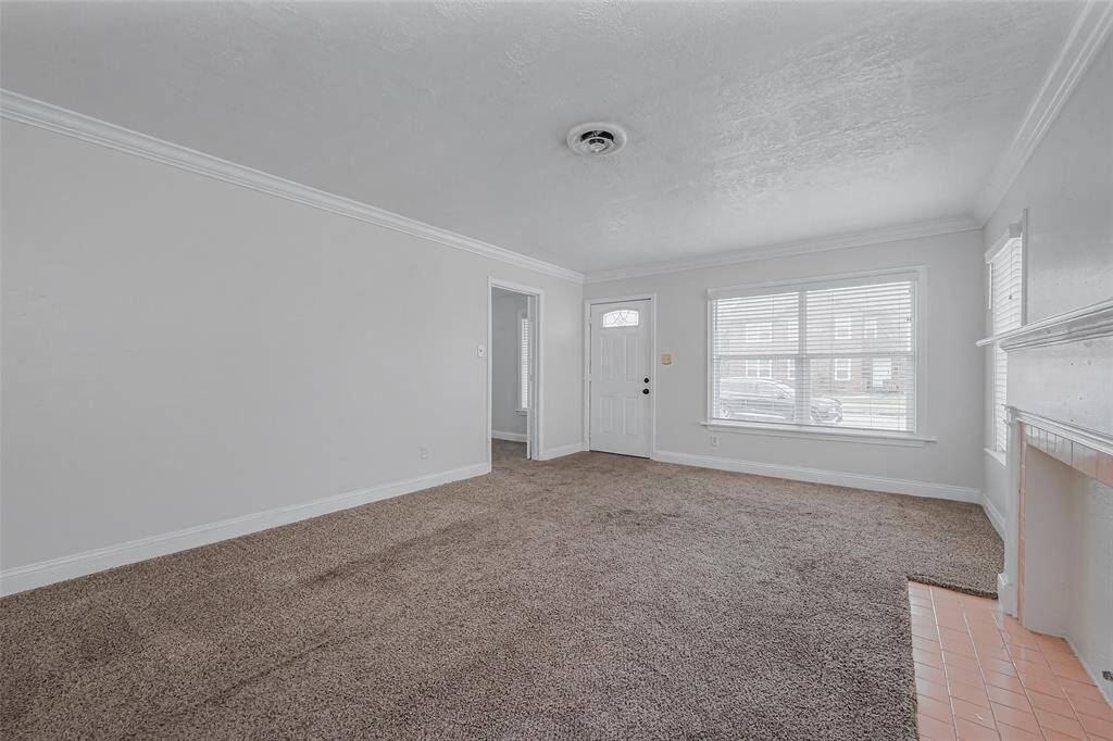 Capturing the full scale of the living room, this perspective highlights its spaciousness and fresh interior updates. The newly painted walls reflect light beautifully, creating a crisp, clean aesthetic.