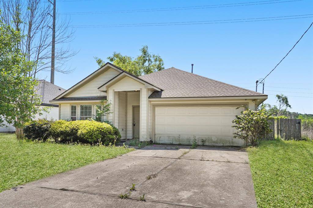 Charming single-story home with a two-car garage and welcoming front porch. Features a well-maintained lawn and mature shrubs.