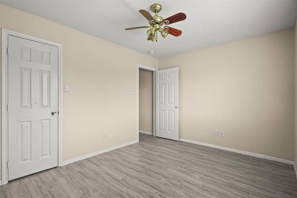This room features wood-look flooring and a ceiling fan with wooden blades.