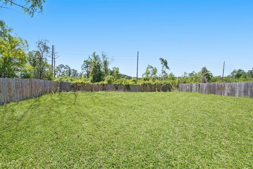 Spacious, well-maintained backyard with lush grass, surrounded by a wooden fence, offering privacy with no back neighbors.