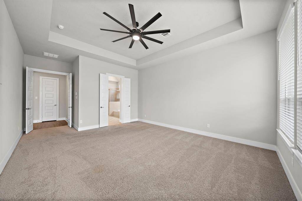 Spacious primary suite provides double doors entering the suite with great natural lighting and a view of your own oasis.