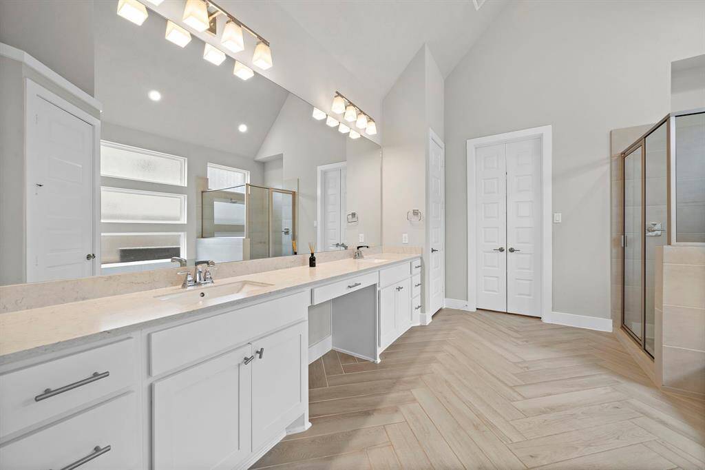 Unwind from your day in the primary bathroom suite featuring two vanities, standing shower and a soaking tub.