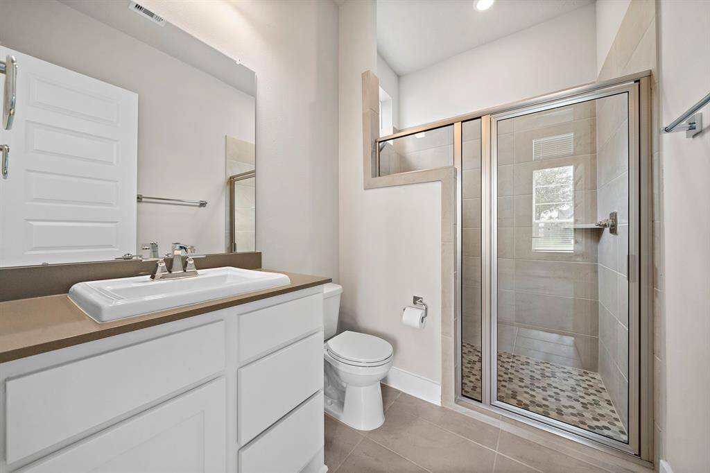 Secondary bathroom located in the secondary bedroom on the first floor complete with a walk-in closet.
