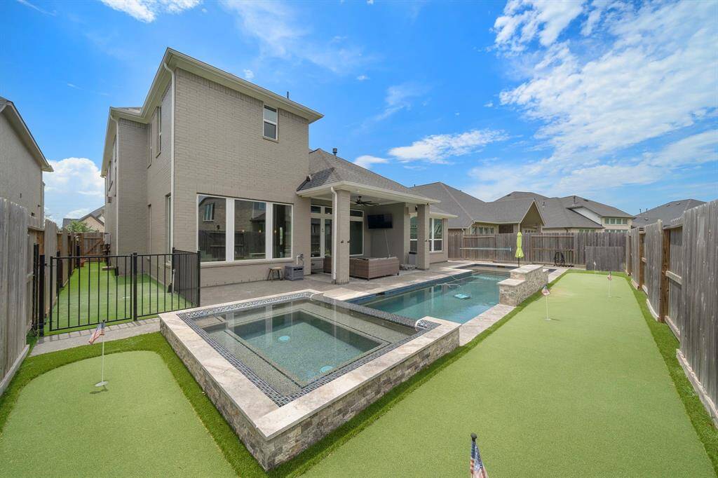 Enjoy the ultimate in outdoor living with a picturesque pool & a putting green, perfect for leisurely afternoons or hosting outdoor gatherings.