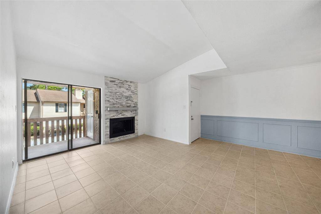 Nice, spacious living area with cute fireplace and access to your own balcony that offers a large storage closet.Floor tile - grey not brown as in the photo.