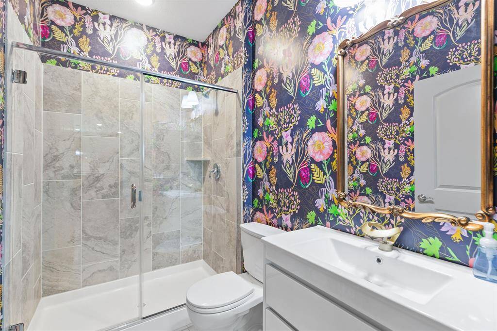 Secondary full bath servicing guests; luxury Perigold wallpaper was added as a touch of glamour.
