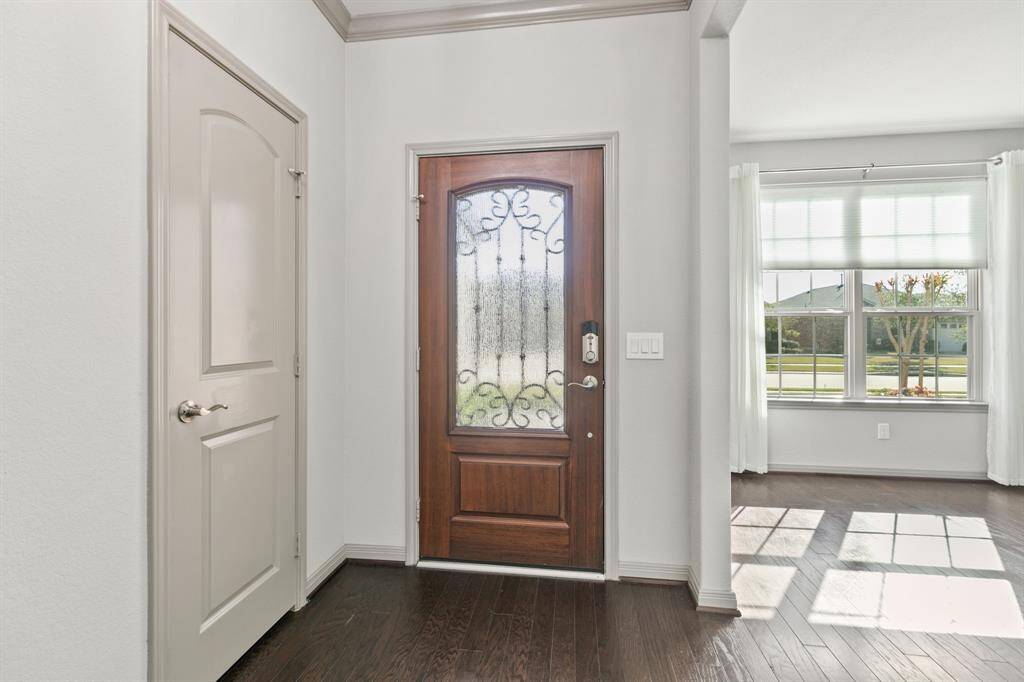 Welcoming entry showcasing neutral colors, glistening wood floors. Office area is shown near front door. Coat closet is next to front door.