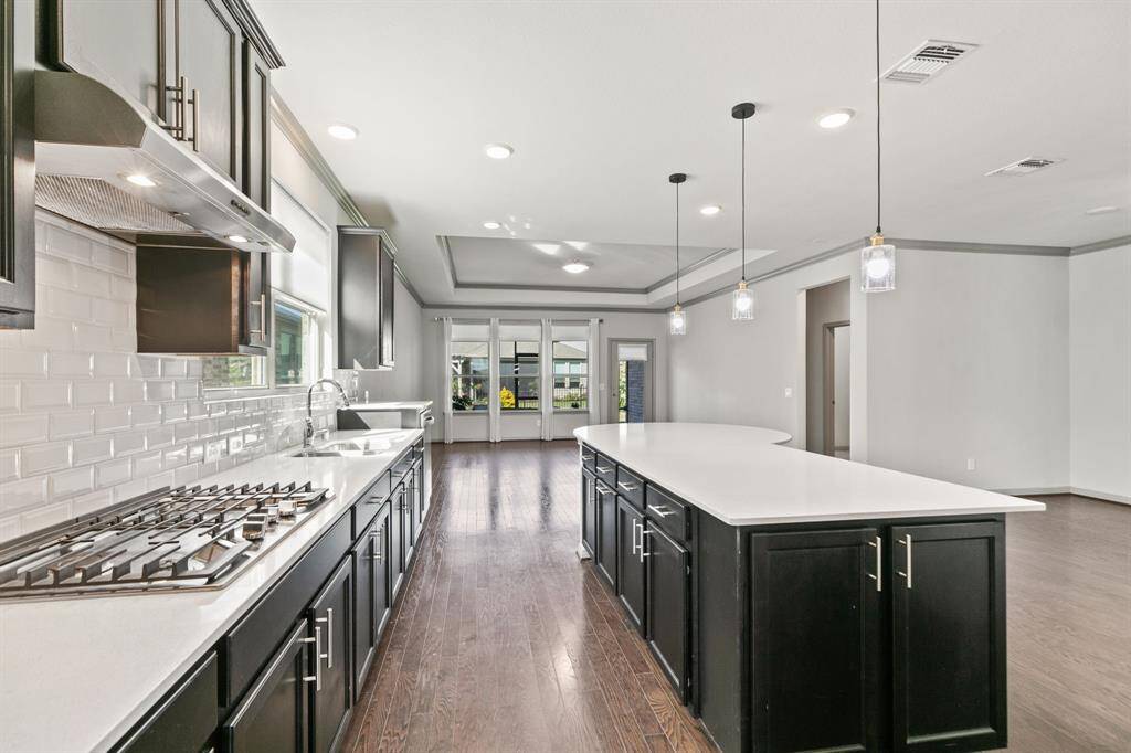 Sleek stainless vent and gas cooktop.