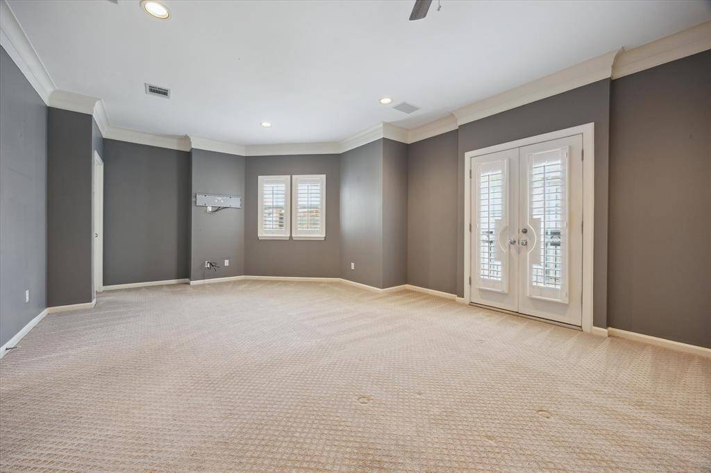Primary bedroom with French doors on the right side that lead to a small balcony (standing room only). Walk-in closet to the left, out of the sight of the picture, with plenty of space for a sitting area.