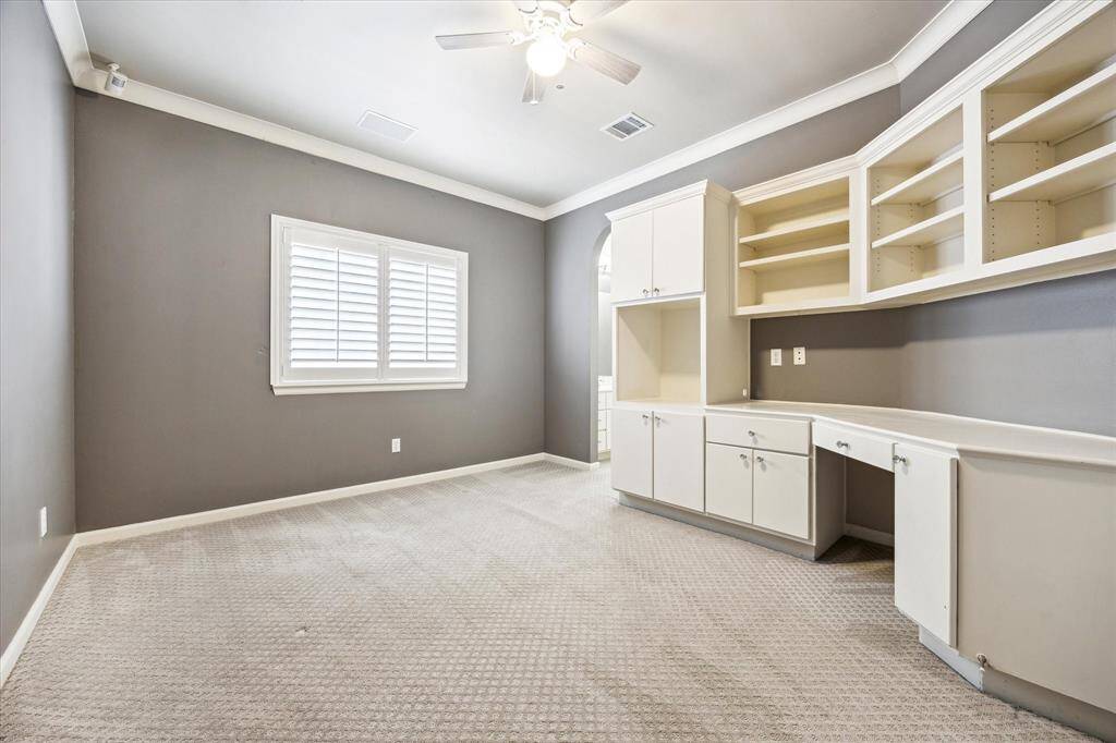 Picture of the secondary bedroom located to the left of the walkway, with build-in drawers and shelves, with a space for a TV. Sink on the left with a walkin closet. A Jack and Jill bathroom.