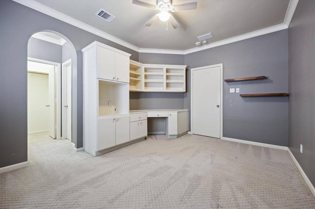 Another picture of the secondary bedroom with build-in cabinets and shelves.
