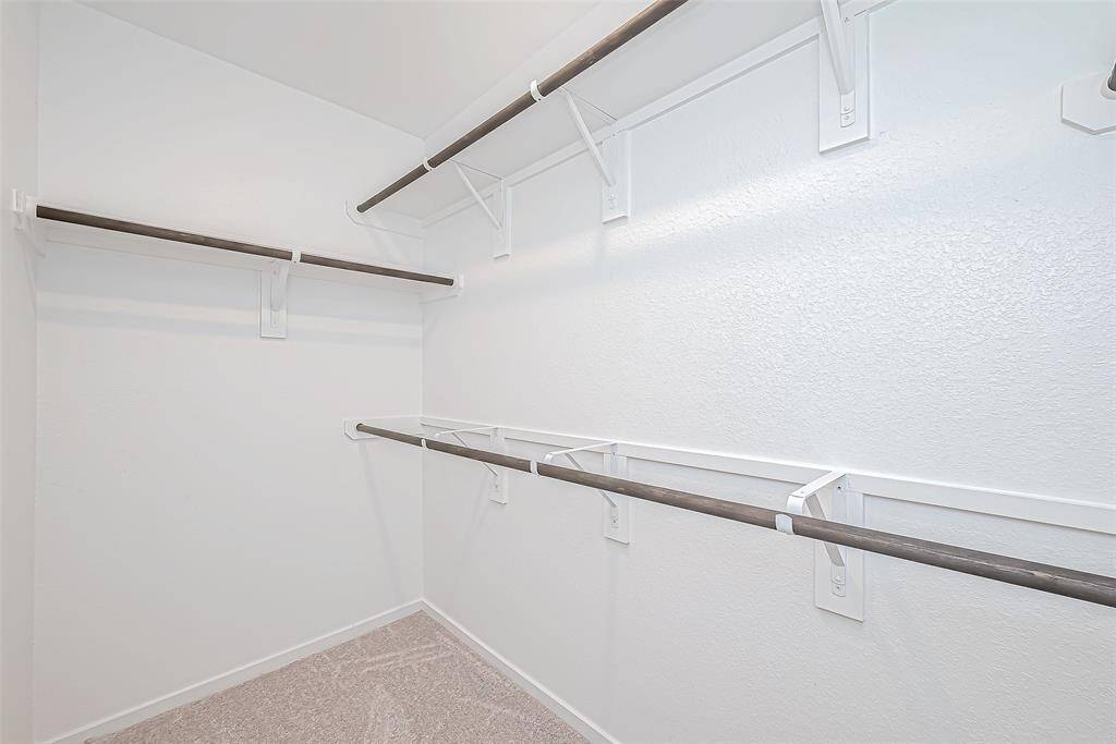 Walk-in closet, with lots of shelves for storage.