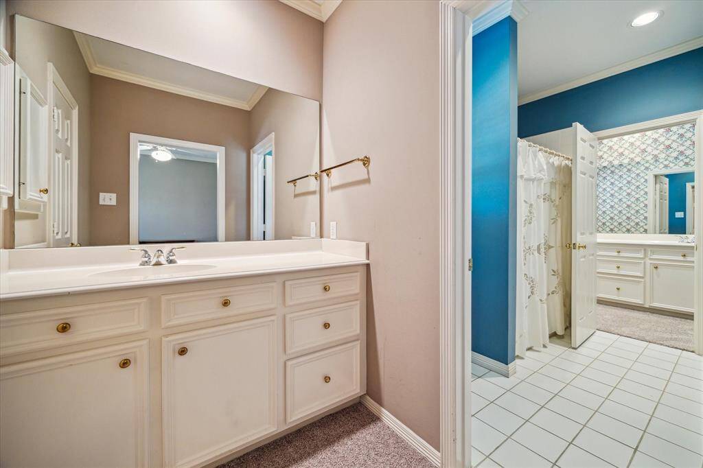 The other sink area for the SHARED UPSTAIRS BATH - carpeted flooring, painted walls, crown/base molding, sink with cabinets/drawers below.