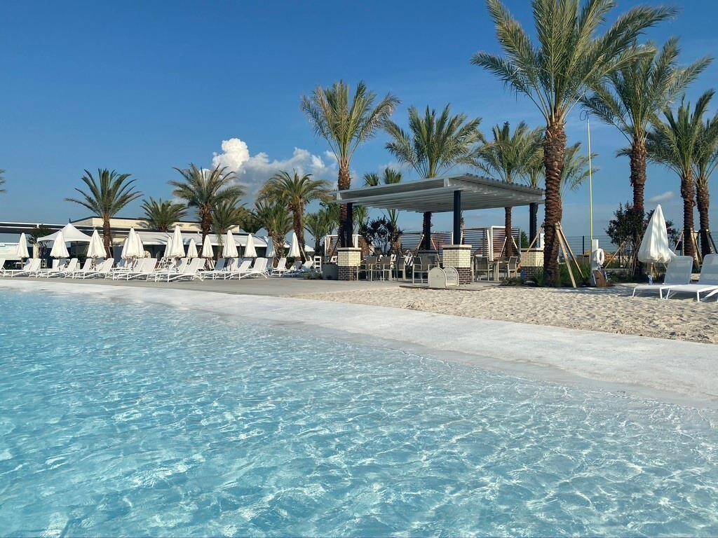 Lounging options include beach chairs, awnings, and cabanas