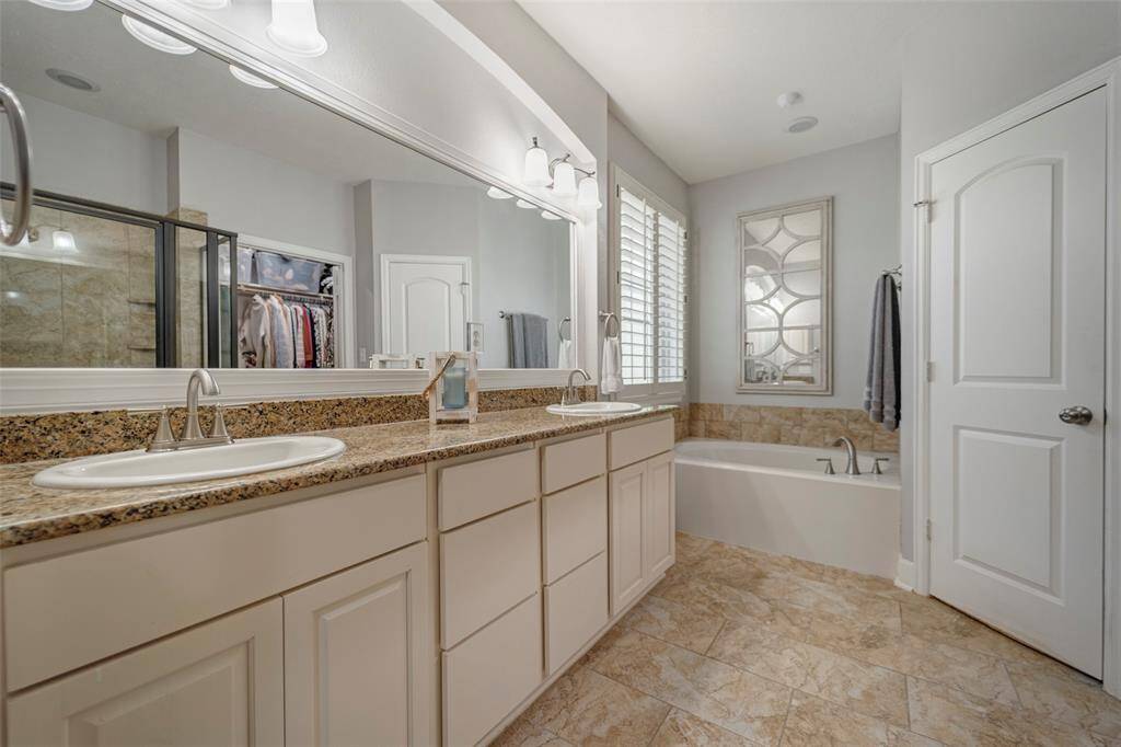 Primary bath with double sinks, separate tub and stand-alone shower.