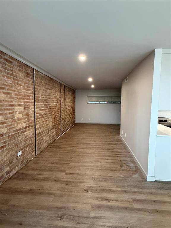 Exposed brick wall adds warmth and character. Use this space for a study, seating or dining area