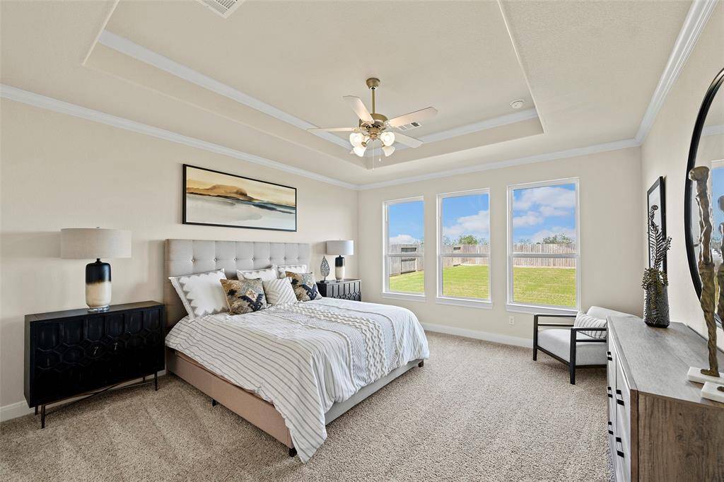 Spacious Primary Bedroom with beautiful tray ceiling with crown molding.