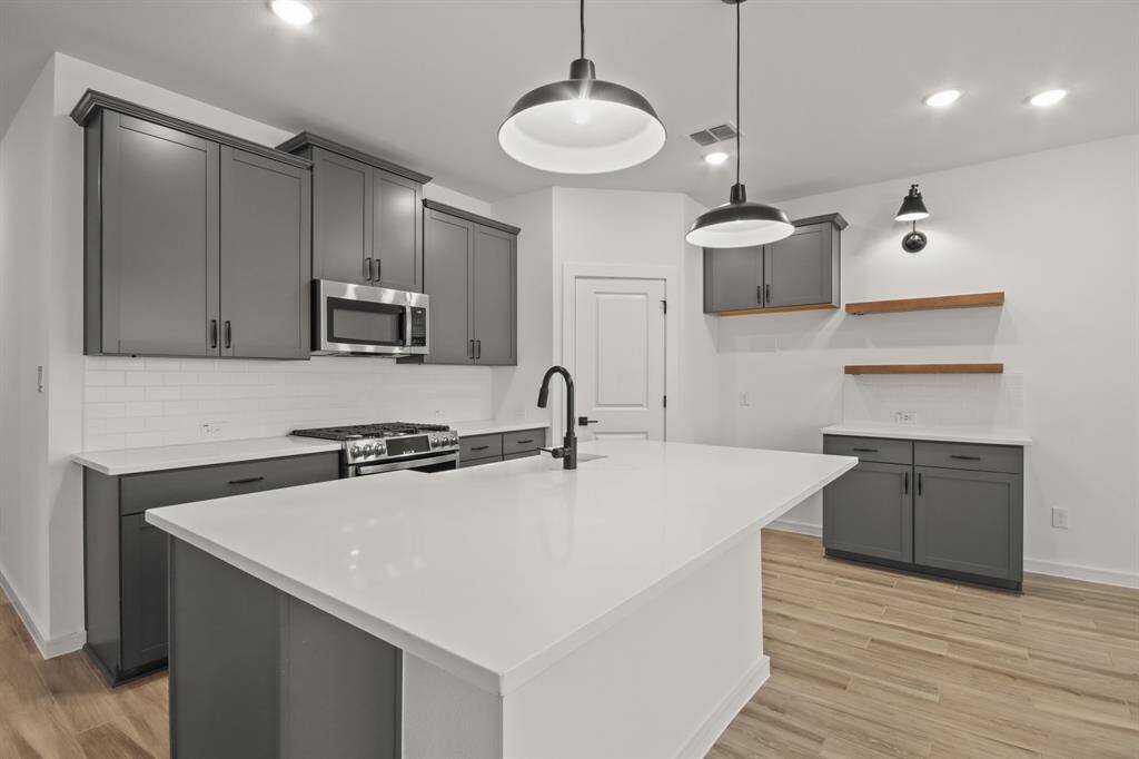 Stylish kitchen with quartz countertops and grey cabinets