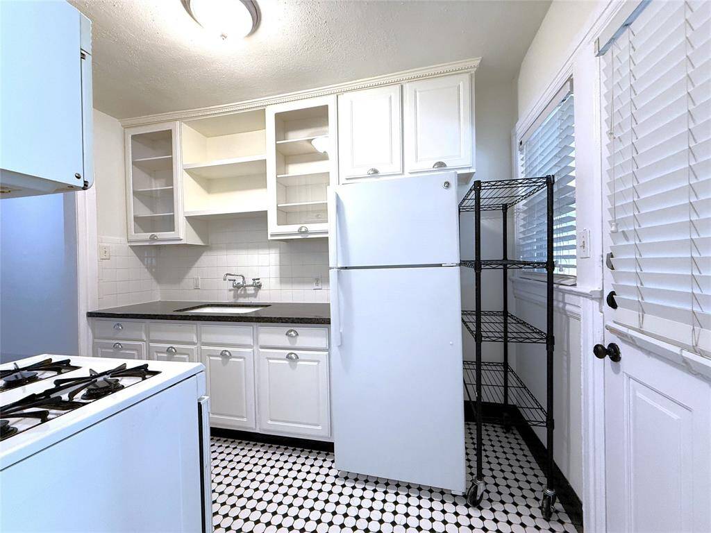 The cute kitchen features glass front cabinets.