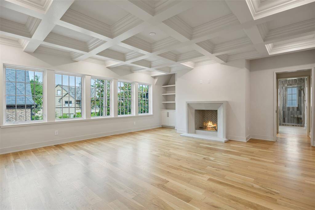 Bathed in natural light from a trio of oversized windows, this secondary bedroom offers a bright and airy atmosphere with wide-plank hardwood floors, recessed lighting, and a modern ceiling fan. Clean lines and thoughtful proportions make it a serene space for rest, study, or relaxation.
