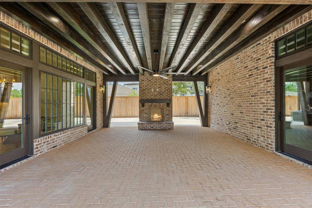 Framed by elegant brickwork and dramatic architectural lines, this show-stopping pool and spa create the ultimate outdoor experience. Whether basking in the sun or gathering beneath the covered lounge with its built-in fireplace, every inch of this backyard oasis invites relaxation and elevated entertaining.