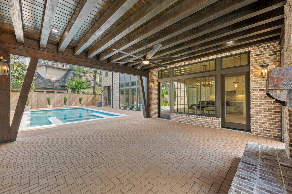 A true backyard oasis, this resort-style pool and integrated spa are framed by elegant brickwork and towering windows that reflect the architectural beauty of the home. With ample patio space for lounging or entertaining, this private retreat invites both relaxation and unforgettable gatherings under the Texas sun.