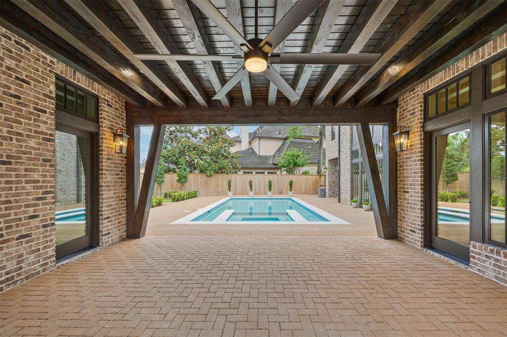 With its rustic wood-beamed ceiling, brick flooring, and wood-burning fireplace, this covered patio creates the perfect ambiance for year-round outdoor enjoyment. Seamlessly connecting the interior and exterior living spaces, it’s an inviting retreat for cozy evenings and lively gatherings alike.